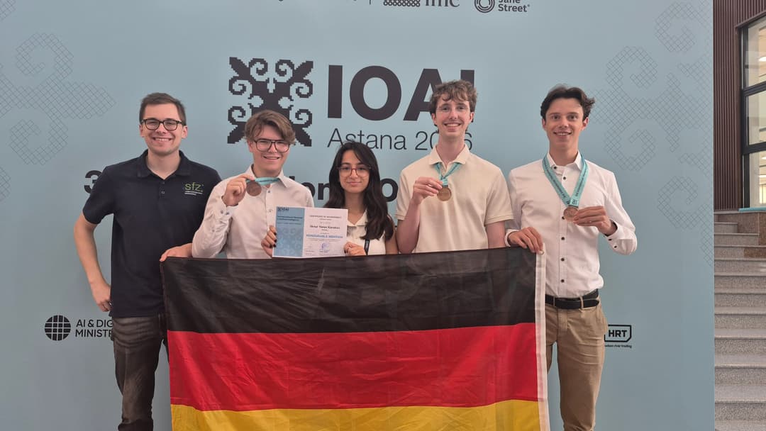 Team Germany holding up a German flag, three bronze medals and an honorable mention certificate in front of the IOAI Astana 2026 backdrop